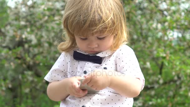 beau garçon intelligent jouer avec un smartphone 