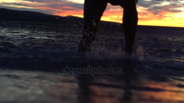 Mișcare lentă: omul care iese din mare la apusul soarelui — Videoclip de stoc