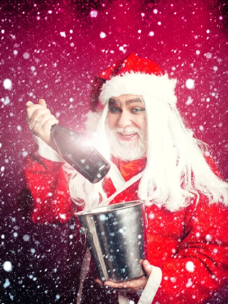 Sorrindo homem de Natal com garrafa no balde — Fotografia de Stock