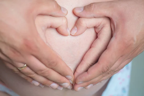 Hands make heart on belly