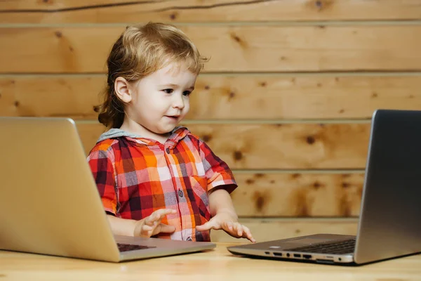 Bonito menino joga em computadores — Fotografia de Stock