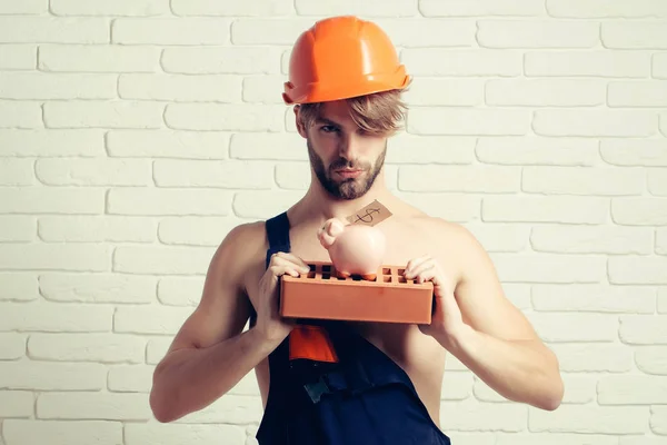 Sexy gespierde man bouwer met moneybox — Stockfoto