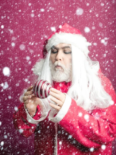 Серьезный рождественский человек с декоративным балом — стоковое фото