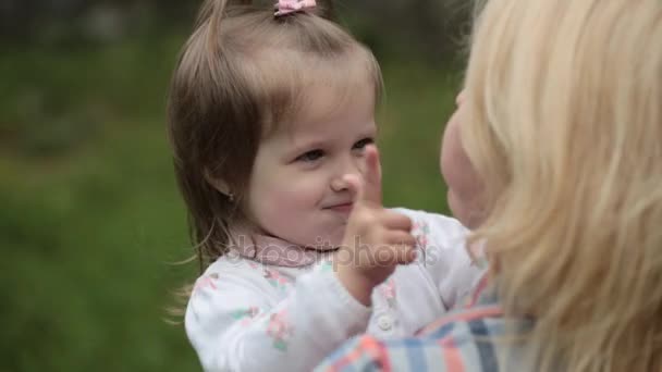 Krásná holčička hraje se svou matkou na pozadí přírody — Stock video