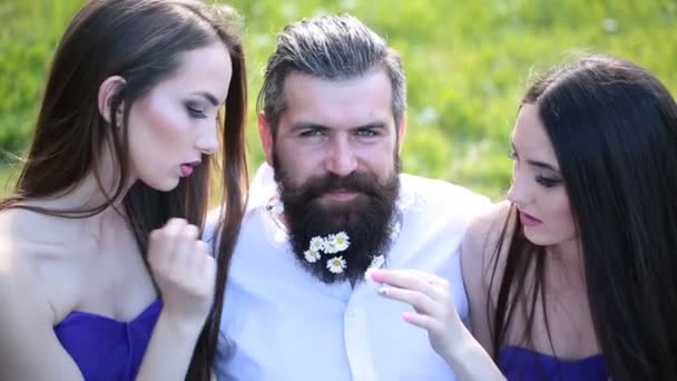 两个女孩在蓝色空房洋甘菊从有吸引力的男人胡子 — 图库视频影像