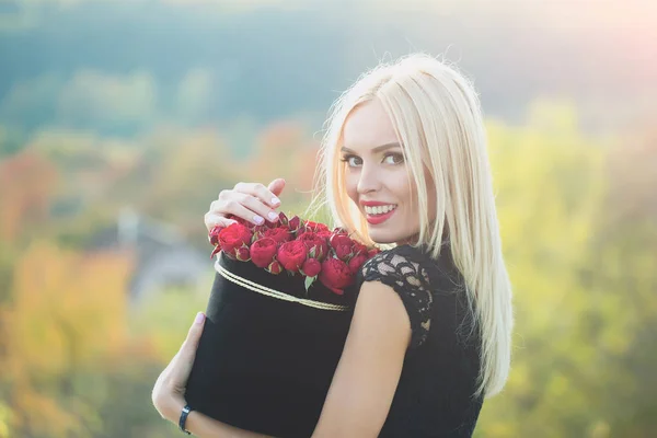 Hübsches Mädchen mit Blumen im Karton — Stockfoto