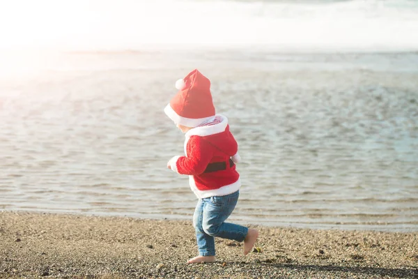 Санта хлопчик на піщаному пляжі води — стокове фото