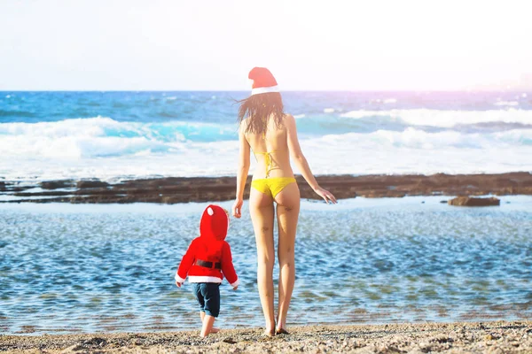 Santa boy y mujer en la playa — Foto de Stock