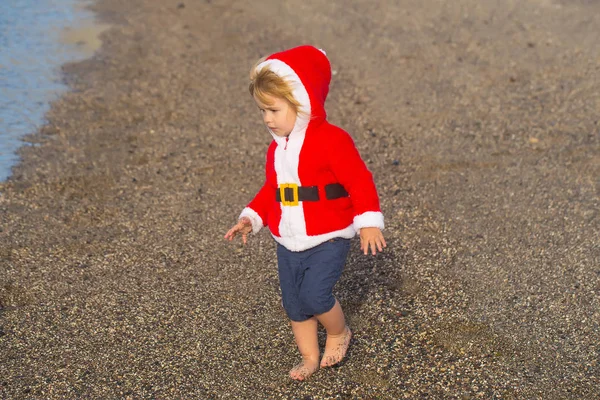 Santa boy på sandstrand vatten — Stockfoto