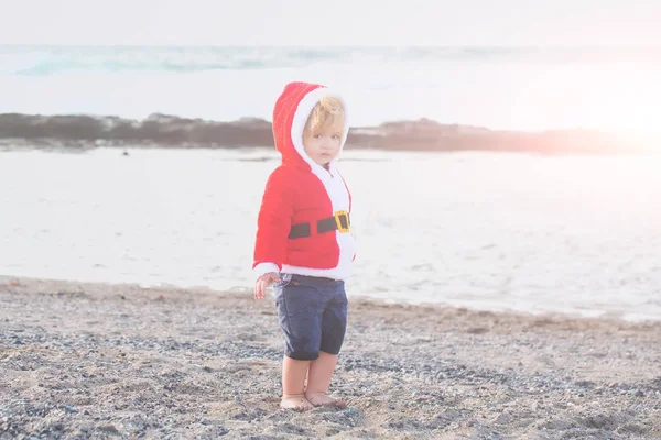 Santa boy på sandstrand vatten — Stockfoto