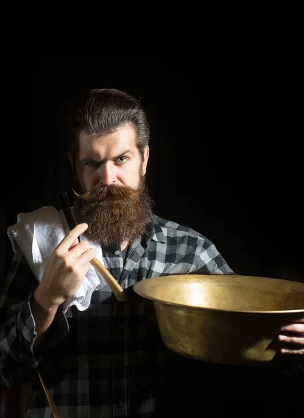 Bearded man shaves with razor