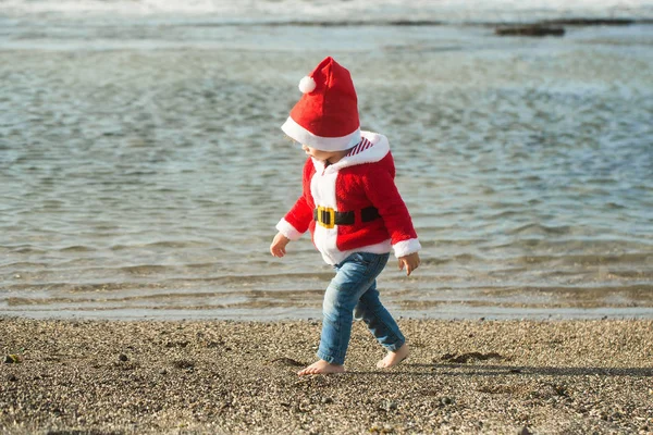 Santa boy at sand beach water — Stock Photo, Image