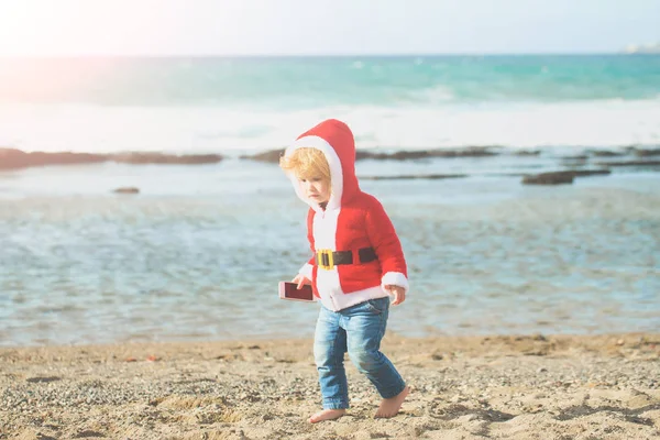 Santa chłopiec o piasek plaża woda — Zdjęcie stockowe
