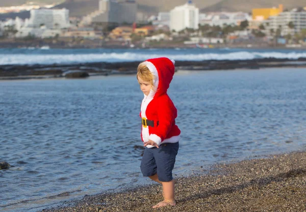 Santa boy på sandstrand vatten — Stockfoto