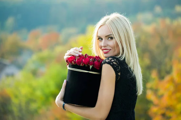 Söt flicka med blommor i rutan — Stockfoto