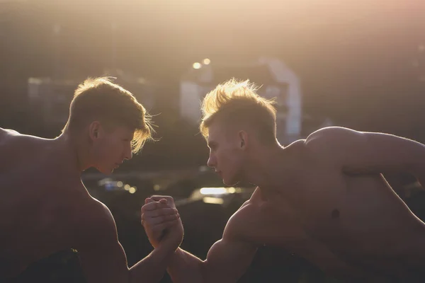 Gêmeos homens fisiculturistas braço wrestling — Fotografia de Stock