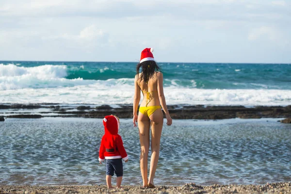 Santa boy y mujer en la playa — Foto de Stock