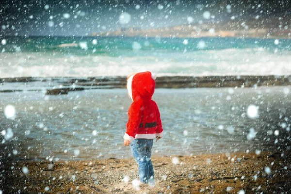 Santa boy på sandstrand vatten — Stockfoto