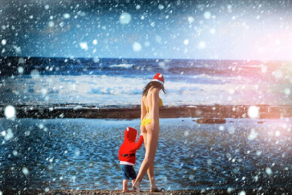 Santa pojken och kvinnan vid stranden — Stockfoto