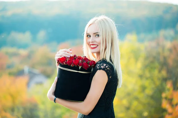 Söt flicka med blommor i rutan — Stockfoto