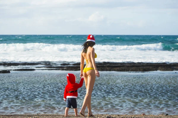 Santa boy y mujer en la playa — Foto de Stock