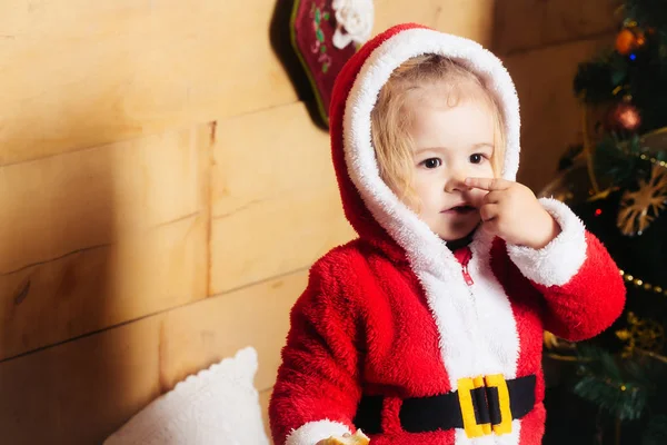 Weihnachtsjunge am Baum berühren Nase — Stockfoto