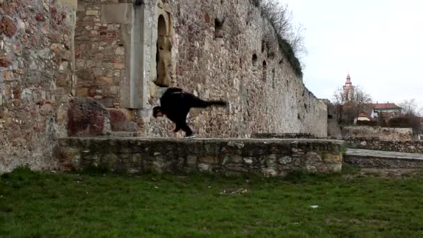 Young sportsman is engaged near the stone wall in the city — Stock Video