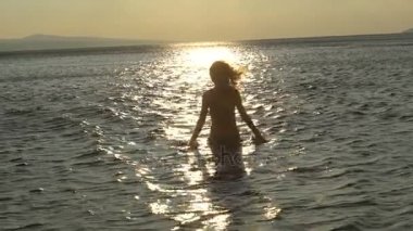 Neşeli kız su ile denizin üzerinde gün anda sevinç seksi kadın bir dinlenme üzerinde oynamak