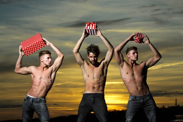 Muskulöse Männer im Sonnenuntergang mit Schachteln — Stockfoto