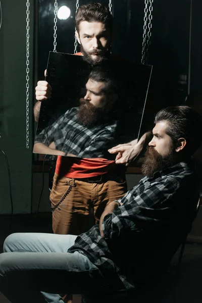 Man holds mirror reflecting customer