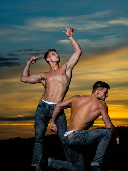 Hombres musculosos en la puesta de sol con cajas — Foto de Stock