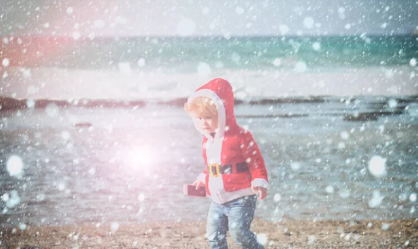 砂のビーチの水でサンタ男の子 — ストック写真