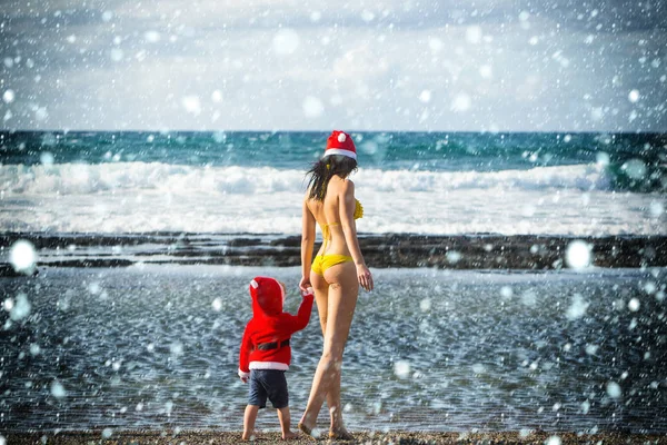 Santa jongen en vrouw aan het strand — Stockfoto