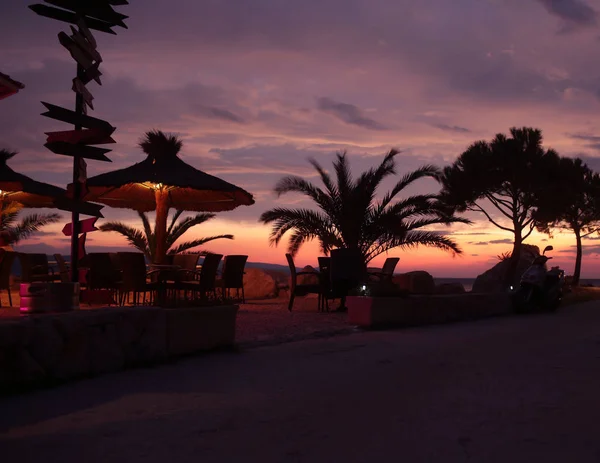 Sunset on seaside promenade and cafe. — Stock Photo, Image