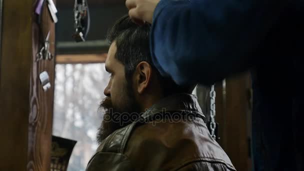 Stylish hairstyle for a bearded man in a leather jacket in Barbershop. Mod customer at a hair salon with him stylist and hairdresser — Stock Video