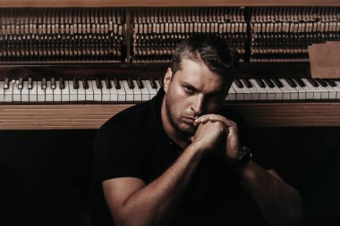 adam ahşap piyano yakınındaki kağıt zarf ile