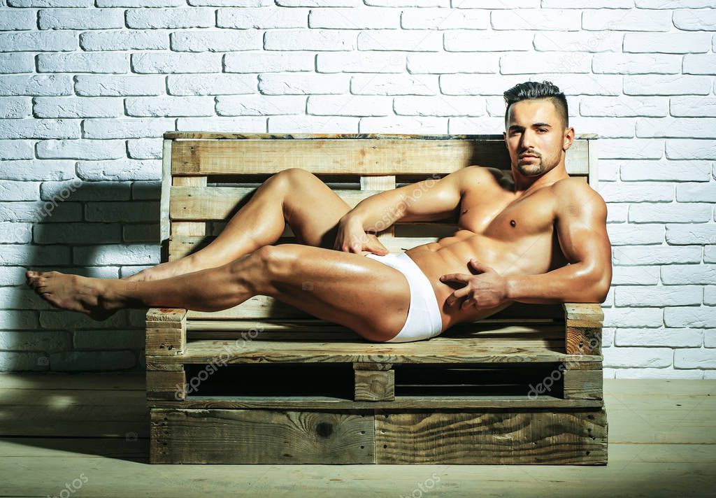 Handsome muscular man on wooden bench