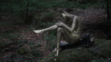 Güzel çıplak peri mistik ıslak ormandaki altın ile vücudu boyama