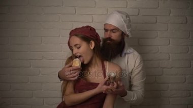 Erkek ve kadın duygusal yeme kekler mutfakta yemek. Sevgi dolu seksi çift yemek ve pudra birbirine tatlı hamur işleri besleme