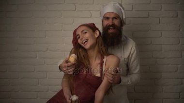 Neşeli iki mutfakta gülümseyen pişirin. Seven çift kek üzerinde özel bir beyaz mutfak hazırlanıyor