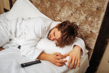 sakallı adam yatakta uzaktan kumandalı