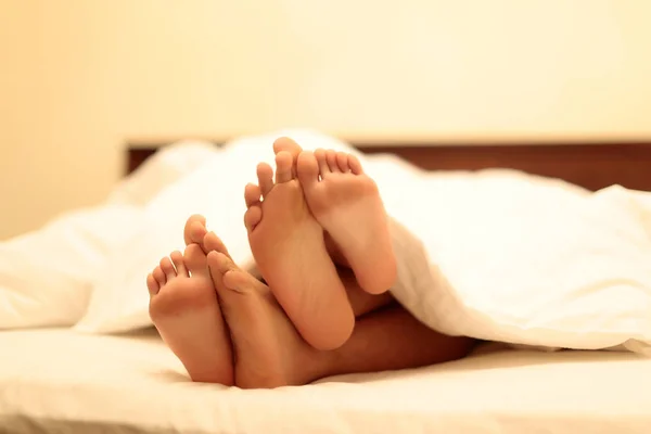 Ανδρικά και γυναικεία πόδια στο κρεβάτι — Φωτογραφία Αρχείου