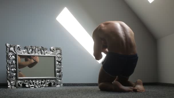 Mladý muž, protáhnout své tělo a vývoj definice jeho svaly na podlaze — Stock video