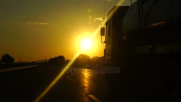 Zeitlupe: LKW auf einer Autobahn bei Sonnenuntergang. zuverlässiger internationaler Transport, Lieferung von Fracht