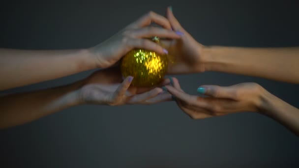 Movimento lento: brinquedo de Natal nas mãos de duas meninas. A paixão eo jogo no ano novo, menina acariciando as mãos uns dos outros com manicure — Vídeo de Stock