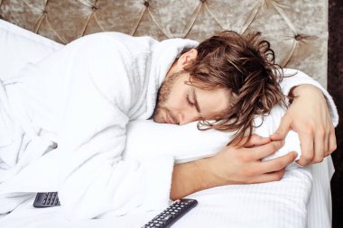 sakallı adam yatakta uzaktan kumandalı