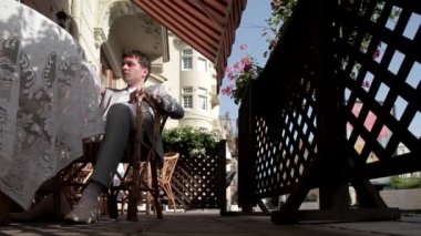 Beyaz elbiseli bir adam tarafından geçen yaz terasında güzel kız