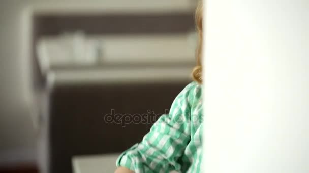 Ребенок с молоком на лице, играющий со своей матерью, смотрящий через стену — стоковое видео