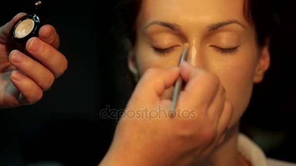 Correção do nariz e do lábio com cremes ou corretor para maquiagem. Maquiagem artista prepara o rosto de uma menina bonita para uma maquiagem à noite — Vídeo de Stock