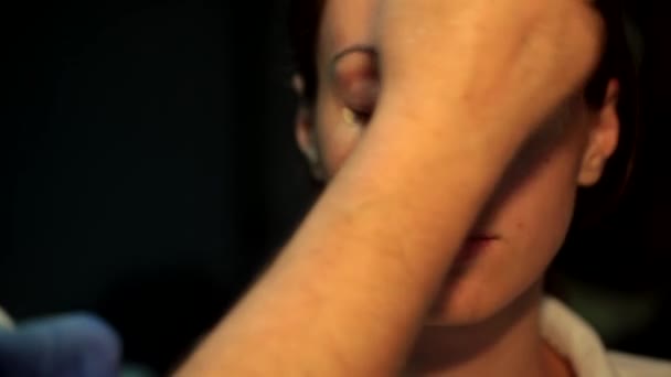 Maskenbildner trägt flüssiges Tonfundament auf das Gesicht der Frau auf — Stockvideo